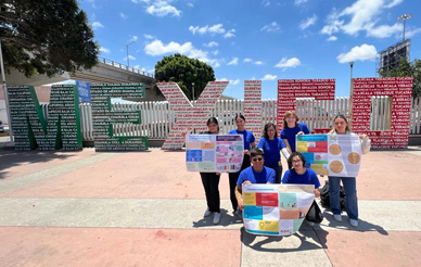 Group of students posing in front of a large sculpture that says "Mexico"